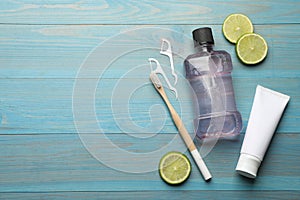 Flat lay composition with mouthwash and other oral hygiene products on turquoise wooden background. Space for text