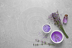 Flat lay composition with natural cosmetic products and lavender flowers on grey stone background