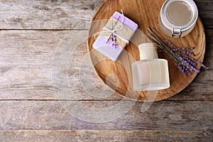 Flat lay composition with natural herbal oil, soap and lavender flowers on wooden background. Space for text