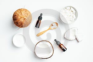 Flat lay composition with natural organic coconut cosmetic for body care. Top view coconut, essential oil, moisturizer cream on