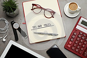 Flat lay composition with notebook on grey table. Tips and Tricks