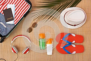 Flat lay composition with open suitcase and beach items