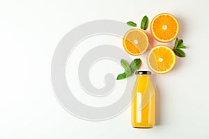 Flat lay composition with orange juice in bottle, oranges and mint on white background, space for text. Citrus drink
