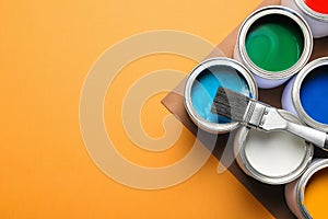 Flat lay composition with paint cans on color background