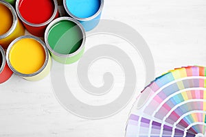 Flat lay composition with paint cans and color palette on wooden background