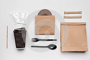 Flat lay composition with paper bags and different takeaway items on white background.