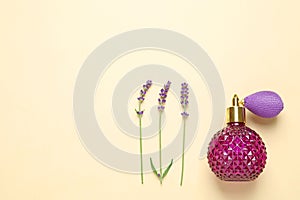 Flat lay composition with  perfume and beautiful flowers on beige background, space for text