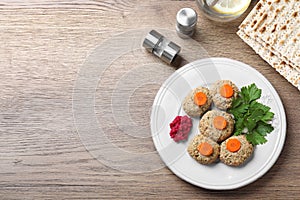 Flat lay composition with plate of traditional Passover Pesach gefilte fish on wooden background