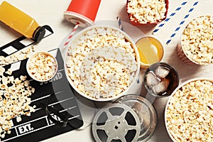 Flat lay composition with popcorn, cinema clapperboard and film reel