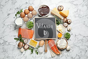 Flat lay composition with products rich in vitamin D on marble table