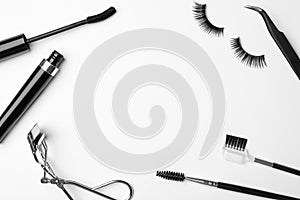 Flat lay composition of professional makeup tools and false eyelashes on white background