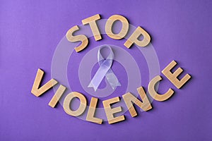 Flat lay composition with purple ribbon and words STOP VIOLENCE on violet background