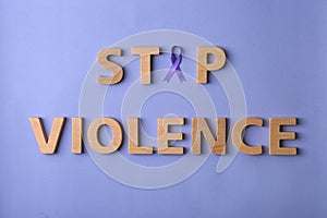 Flat lay composition with purple ribbon and words STOP VIOLENCE on violet background