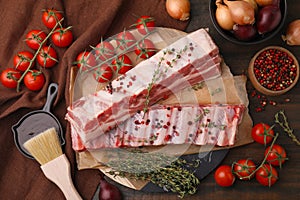 Flat lay composition with raw pork ribs and sauce on wooden table