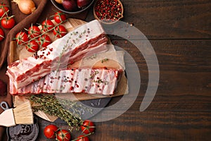 Flat lay composition with raw pork ribs and sauce on wooden table. Space for text