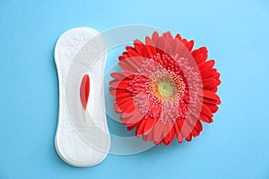 Flat lay composition with red flower and menstrual pad