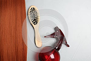 Flat lay composition with red hair and hairdresser`s tools on light background