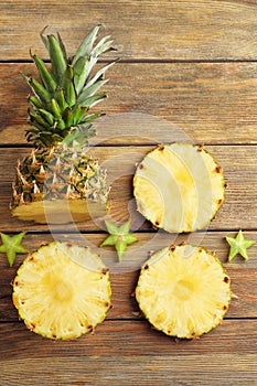 Flat lay composition with ripe fresh pineapple on wooden table