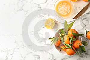 Flat lay composition with ripe tangerines and juicer on marble background.