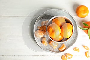 Flat lay composition with ripe tangerines on white wooden background.