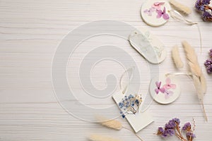 Flat lay composition with scented sachets on white wooden table, space for text