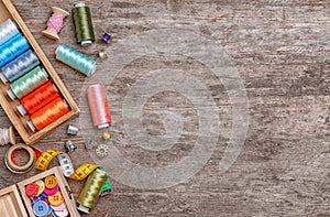 Flat lay composition with sewing threads and accessories on wooden background