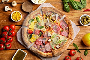 Flat lay composition with slices of delicious pizzas on wooden table