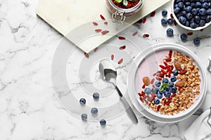 Flat lay composition of smoothie bowl with goji berries on marble table