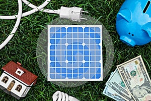 Flat lay composition with solar panel, house model and money