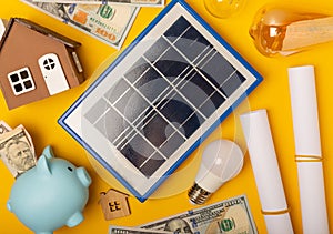 Flat lay composition with solar panel, led lamp and piggy bank on background.