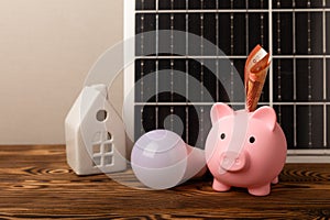 Flat lay composition with solar panel, led lamp and piggy bank on background.