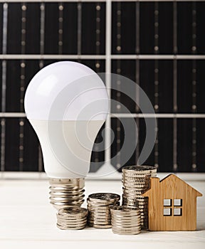 Flat lay composition with solar panel, led lamp and piggy bank on background.