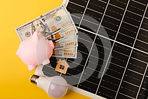 Flat lay composition with solar panel, led lamp and piggy bank on background.