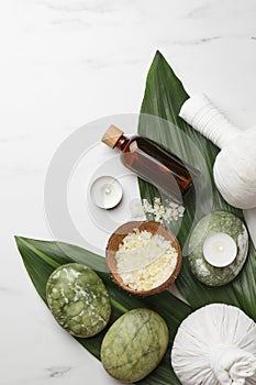 Flat lay composition with spa products .and candles on white marble table. Space for text
