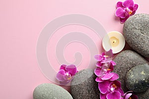 Flat lay composition with spa stones and orchid flowers on pink background