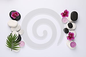 Flat lay composition with spa stones, palm tree leaf and flowers on white background, space for text