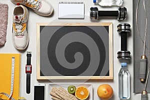 Flat lay composition with sport equipment and blackboard on gray background, space for text.