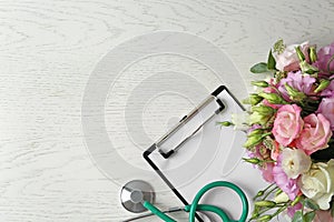 Flat lay composition with stethoscope and flowers on  wooden background, space for text. World health day