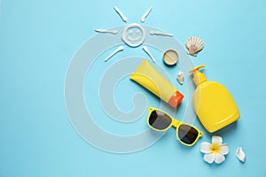 Flat lay composition with sun protection cosmetic products on blue background