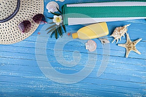 Flat lay composition with sunscreen, glasses, hat and seashells