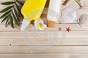 Flat lay composition with sunscreen and seashells on wooden background