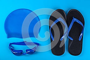 Flat lay composition with swimming accessories on blue background