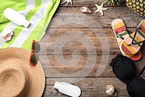 Flat lay composition with swimsuit and beach accessories on wooden background