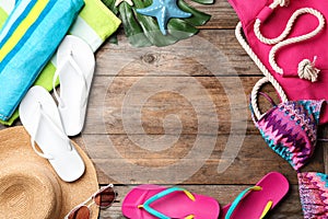 Flat lay composition with swimsuit and beach accessories on wooden background