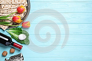 Flat lay composition with symbolic Pesach Passover Seder items on blue wooden table, space for text