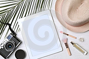 Flat lay composition with tablet and travel blogger`s stuff on white wooden table