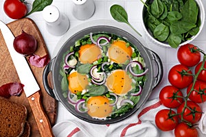 Flat lay composition with tasty green Shakshouka and ingredients on white table