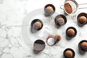 Flat lay composition with tasty raw chocolate truffles on marble background