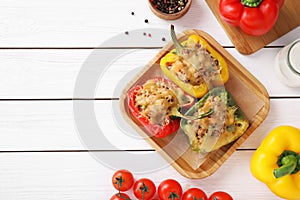 Flat lay composition with tasty stuffed bell peppers on wooden table, top view