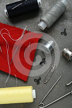 Flat lay composition with thimbles and different sewing tools on grey table
